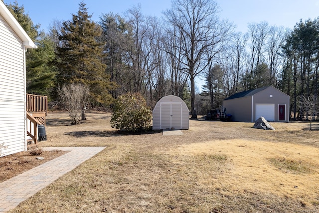 view of yard featuring an outbuilding, a storage unit, a garage, and dirt driveway