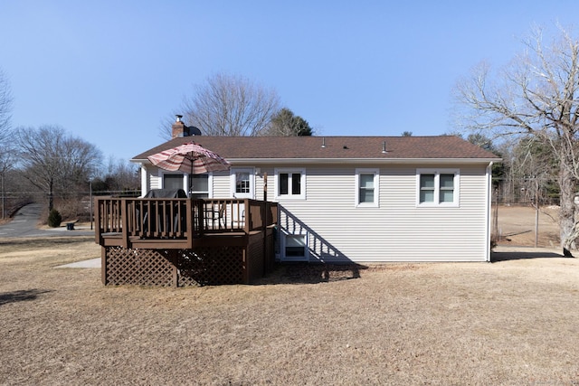 rear view of property featuring a deck and a chimney