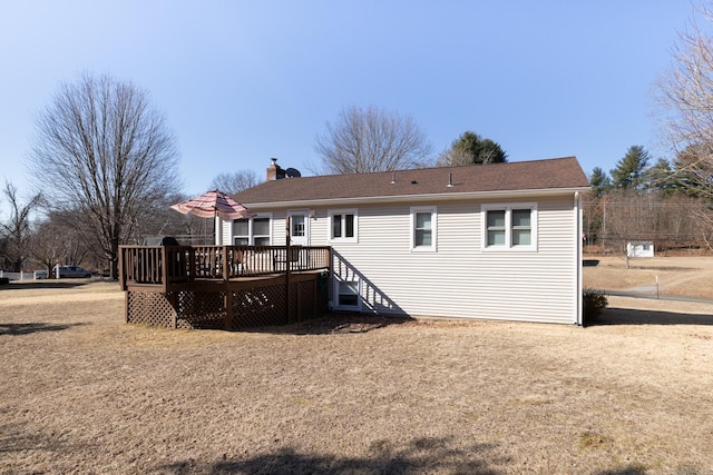 rear view of house featuring a deck and a chimney