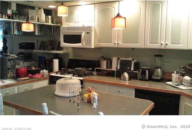 kitchen featuring white cabinetry, pendant lighting, dishwasher, and stove