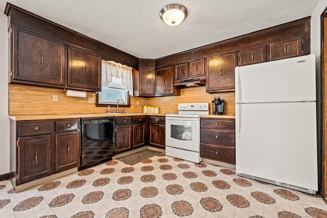 kitchen featuring dark brown cabinetry, white appliances, light countertops, and a sink