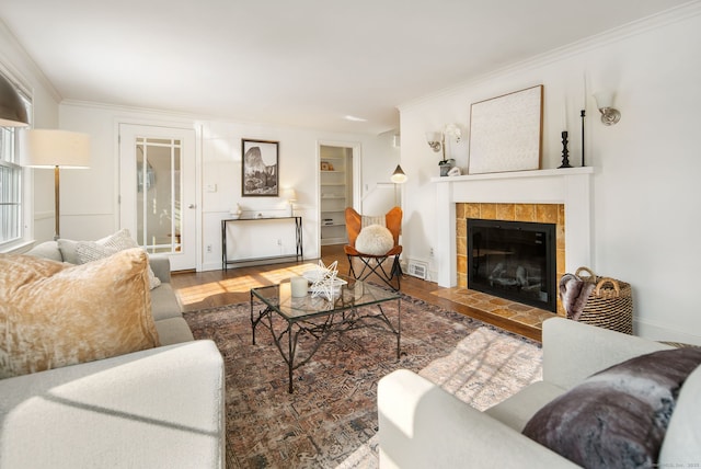 living room featuring a fireplace, hardwood / wood-style flooring, and crown molding