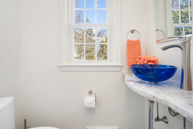 bathroom with a wealth of natural light, sink, and toilet