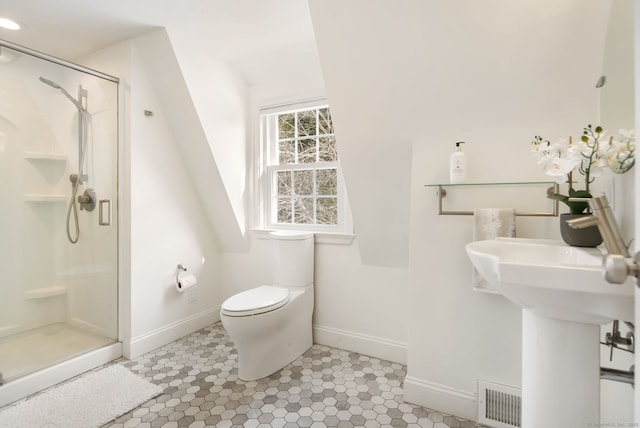 bathroom featuring toilet and a shower with door