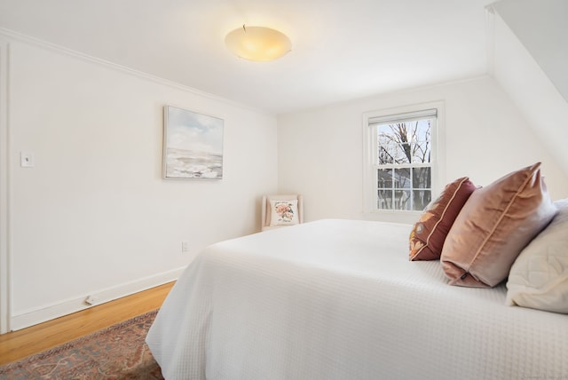 bedroom featuring vaulted ceiling and wood-type flooring