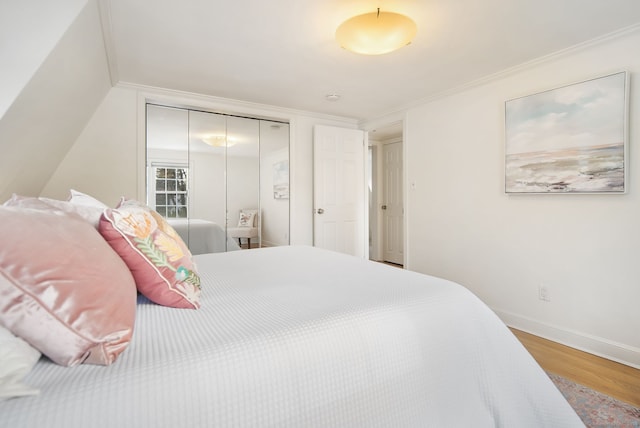 bedroom with a closet, wood-type flooring, and ornamental molding