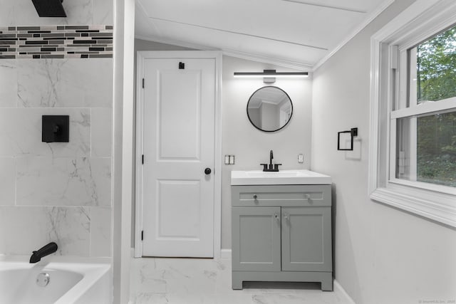 bathroom featuring ornamental molding, lofted ceiling, bathing tub / shower combination, and vanity