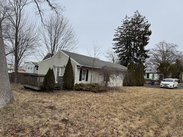 view of property exterior featuring a yard and a wooden deck