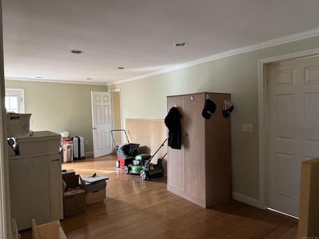 interior space with baseboards, wood finished floors, and crown molding