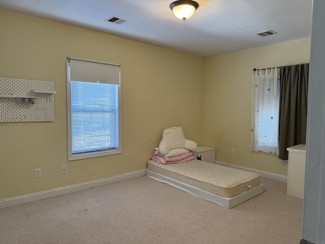 unfurnished bedroom with light carpet, visible vents, and baseboards