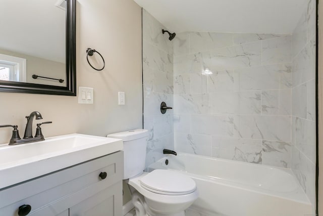 full bathroom with tiled shower / bath, vanity, and toilet