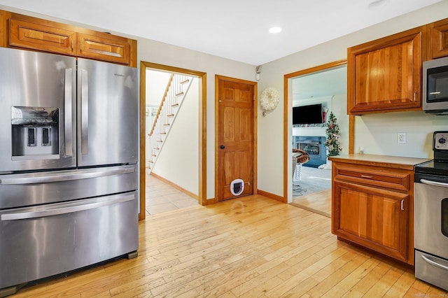 kitchen featuring stainless steel appliances and light hardwood / wood-style flooring