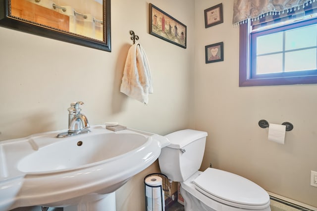 bathroom featuring sink, a baseboard radiator, and toilet