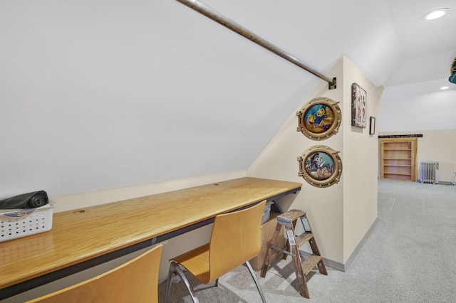 office featuring radiator heating unit, vaulted ceiling, and light colored carpet