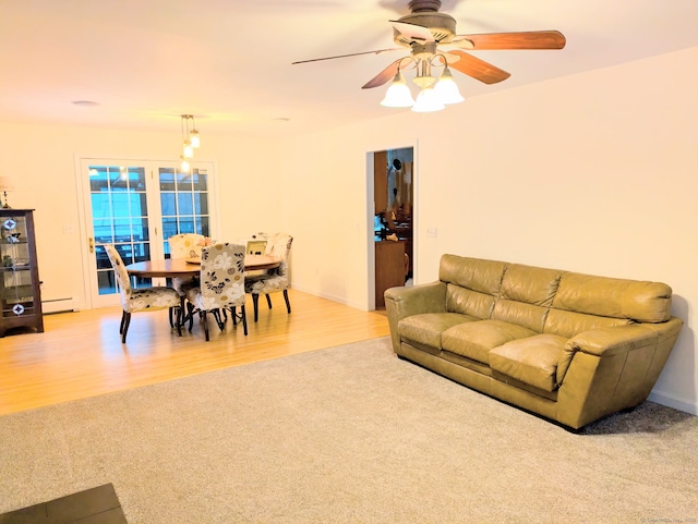 living room with baseboard heating, ceiling fan, and light wood-type flooring