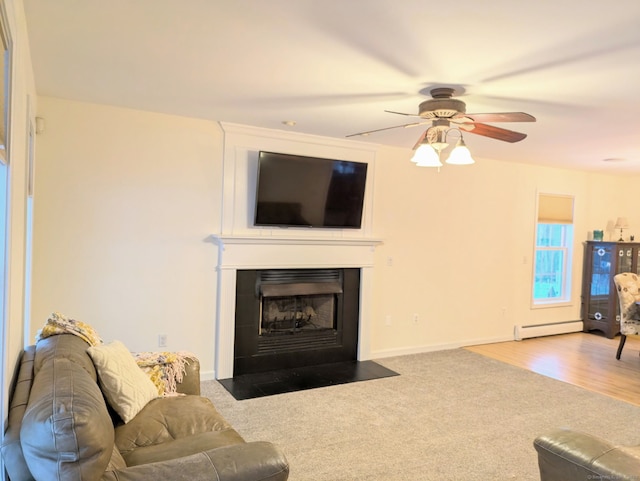 carpeted living room featuring ceiling fan, a fireplace, and baseboard heating