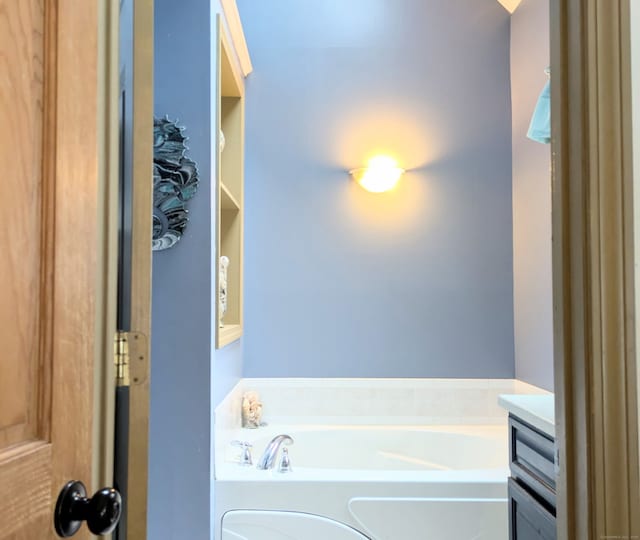 bathroom featuring a washtub and vanity