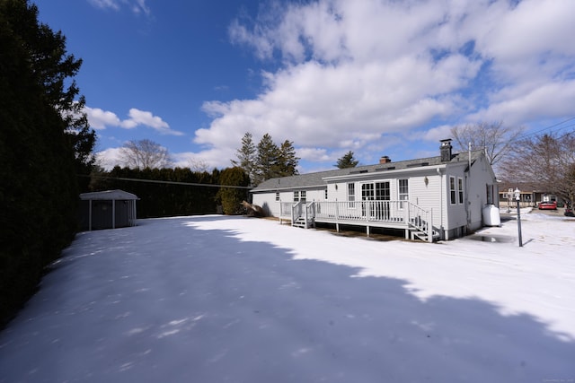 rear view of house with a chimney and a deck