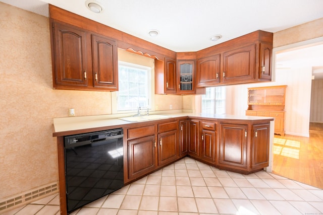 kitchen with light countertops, brown cabinetry, glass insert cabinets, a sink, and dishwasher