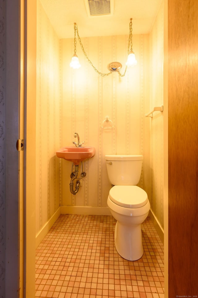 half bath featuring wallpapered walls, visible vents, baseboards, toilet, and tile patterned flooring