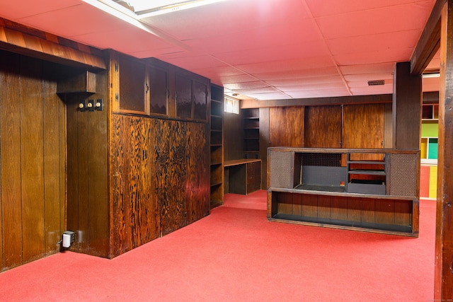 interior space with wood walls, carpet, and visible vents