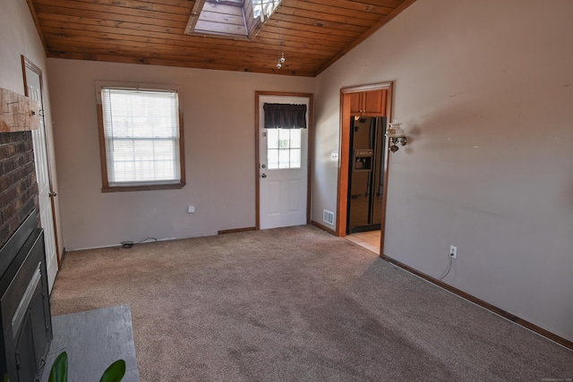 unfurnished living room featuring light carpet, vaulted ceiling with skylight, wood ceiling, and visible vents