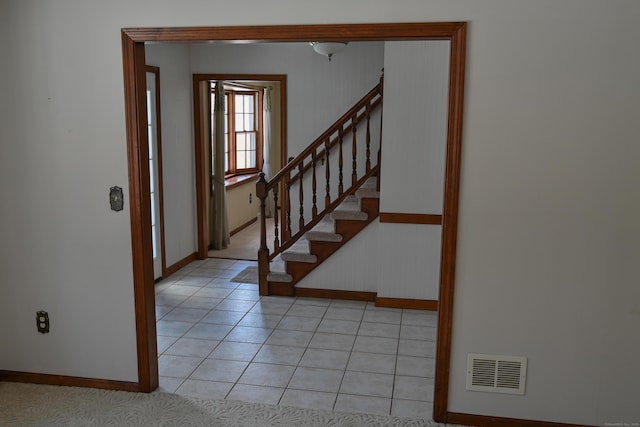 foyer with light tile patterned floors, stairs, visible vents, and baseboards