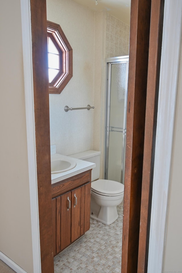 bathroom with toilet, a stall shower, and vanity