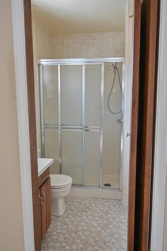 bathroom featuring a stall shower, vanity, and toilet