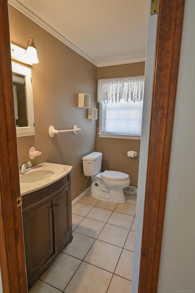 bathroom featuring toilet, ornamental molding, vanity, baseboards, and tile patterned floors