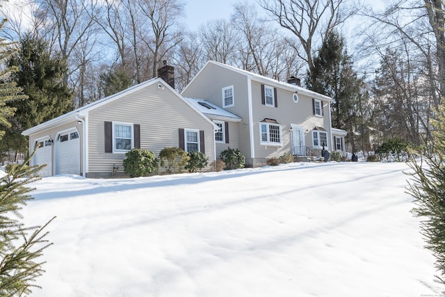 colonial-style house with a garage and a chimney