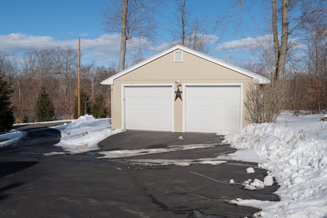 snow covered garage with a garage