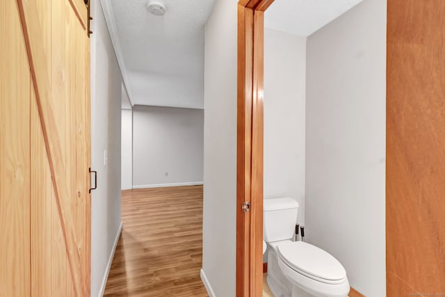 bathroom featuring a textured ceiling, toilet, and hardwood / wood-style flooring