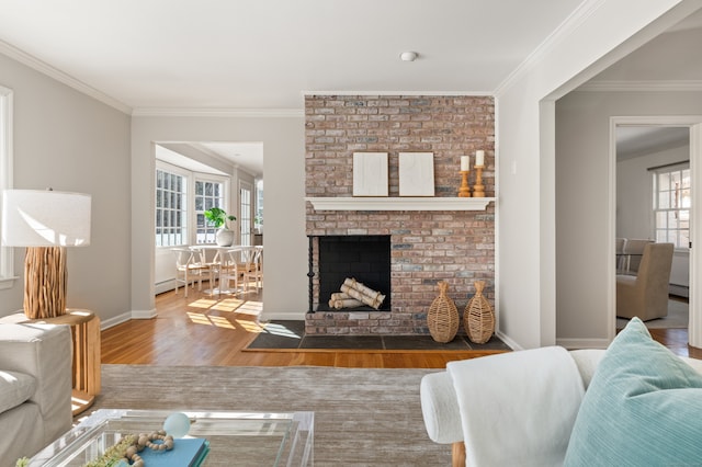 living room with ornamental molding, dark wood finished floors, a brick fireplace, and plenty of natural light