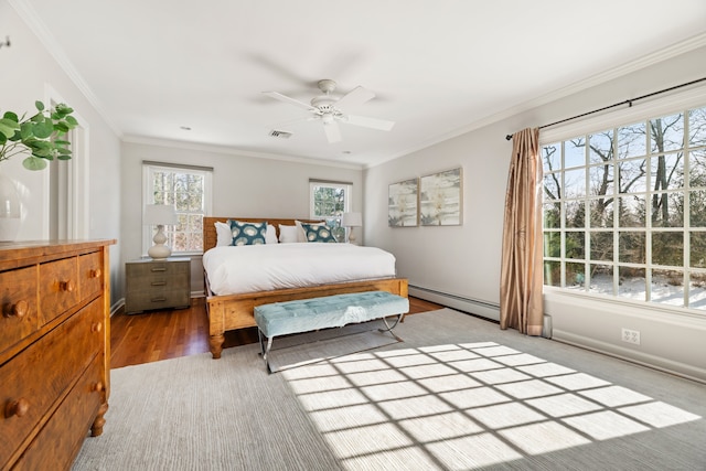 bedroom with visible vents, baseboards, light wood-style floors, baseboard heating, and crown molding