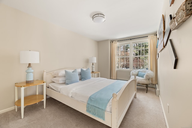 bedroom featuring light carpet and baseboards