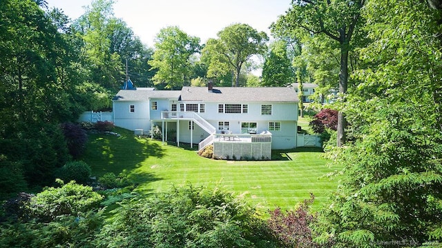 rear view of property with a wooden deck, stairs, and a yard