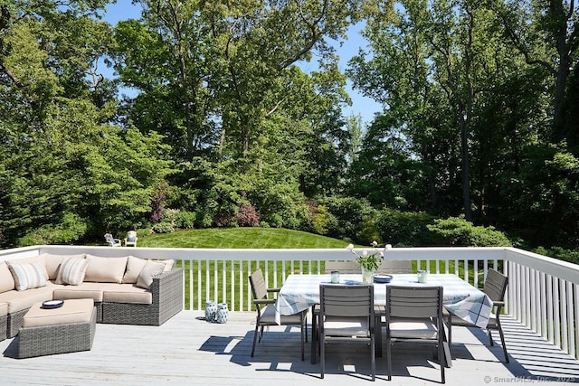 wooden terrace with an outdoor hangout area, a yard, and outdoor dining space