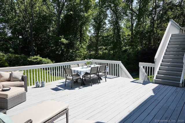 deck featuring stairway and outdoor dining area