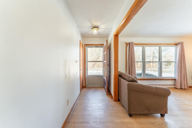 hall featuring baseboards and light wood-type flooring