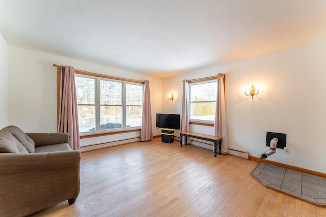 living area with light wood-style floors, baseboards, baseboard heating, and a baseboard radiator