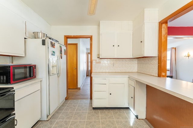 kitchen with backsplash, white cabinetry, light countertops, and range