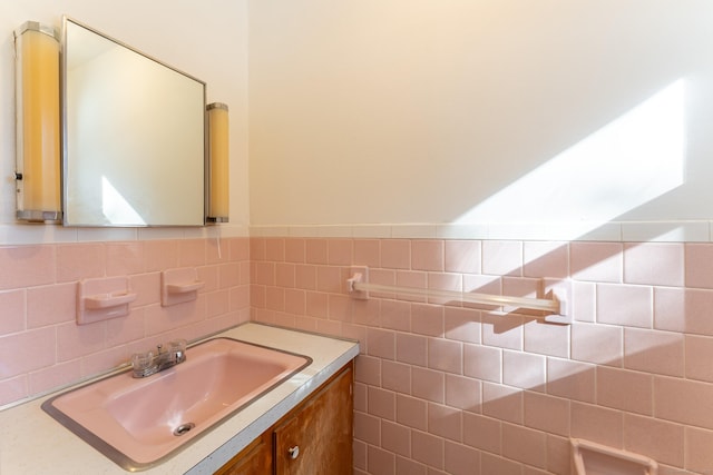 bathroom with a wainscoted wall, tile walls, and vanity