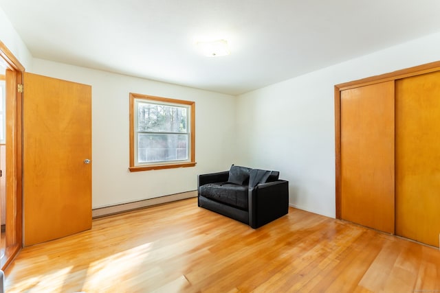 living area with light wood finished floors and a baseboard radiator