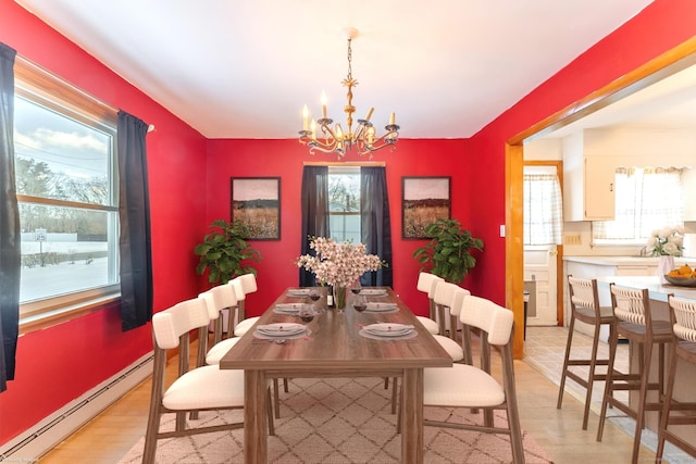 dining room featuring a notable chandelier, a healthy amount of sunlight, and a baseboard radiator