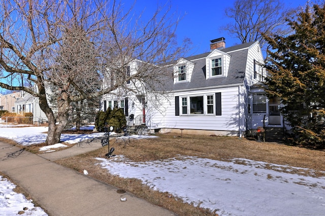 view of front of property with roof with shingles, a chimney, and a gambrel roof