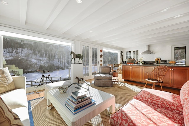 sunroom with a wealth of natural light, beamed ceiling, and french doors