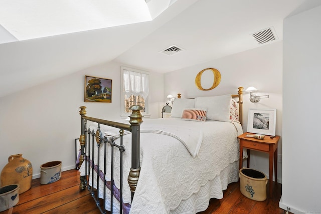 bedroom with lofted ceiling, hardwood / wood-style flooring, baseboards, and visible vents