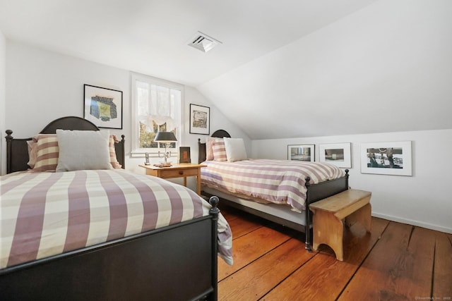 bedroom with vaulted ceiling, light wood-type flooring, and visible vents