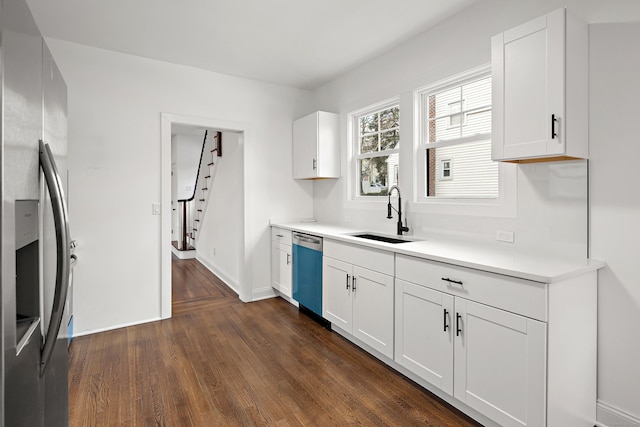 kitchen with stainless steel fridge, dark wood finished floors, dishwasher, light countertops, and a sink